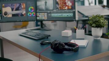 Empty creative multimedia studio with professional computer placed on desk, dual monitor setup. editing start up company agency with no people in it and post production software on pc displays video