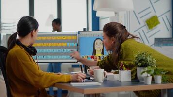 Team of women retouchers working with modern photo editing software app in digital multimedia company, discussing and taking notes. Art director consulting designer colleague, retouching portrait video