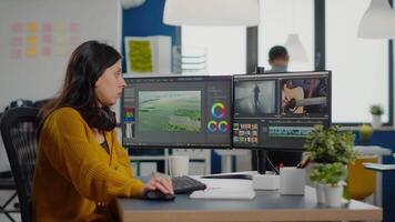 Team of women videographers working with modern post production software in digital multimedia company, looking at graphs in clipboard. maker employees processing film montage in creative agency video