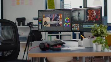 Empty creative workplace with professional computer placed on desk, dual monitor setup. editing start up studio company agency with no people in it and post production software on pc displays video