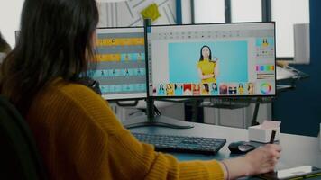 Woman designer, photo editor specialist working at pc in creative office environment using stylus pencil. Retoucher woman retouching fashion assets in digital graphics editing software, color grading video