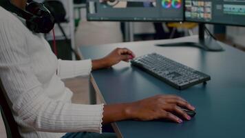 Close up of african editor turning head at camera looking and smiling working in start up creative agency office. Black videographer editing project using post production software video