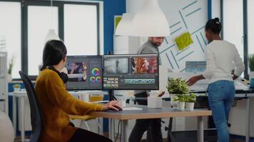editor and sound engineer working togenther at project, editing audio and film footage in post production software. Women videographers processing movie montage sitting in creative agency office video