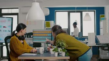 Graphic designers analysing client assets from displays checking color greading and taking notes. Retouchers working in photo editing software app holding stylus pen sitting in creative acgency office video