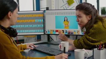 Photographers using professional retouching software or application to edit photos with stylus pen, discussing in front of computer with dual monitors setup. Project managet pointing on display. video
