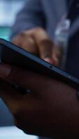 Vertical Software developer doing yearly maintenance using tablet to prolong data center equipment life span. Extreme close up of worker in server hub monitoring server infrastructure using device, camera B video