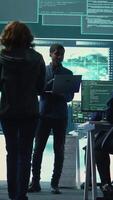 Vertical Governmental hackers performing a cyber attack simulation after studying the national database servers. Experts working on IT security, data breach prevention against ransomware. Camera B. video
