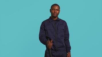 Happy security guard doing thumbs up sign gesturing with finger, preventing public access in restricted area. Portrait of smiling bodyguard doing positive hand gesture, studio background, camera B video