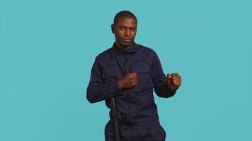 Security guard standing in fighting stance, prepared to deal with people entering restricted area. Portrait of bodyguard holding defensive pose, ready to throw punches, studio background, camera B video