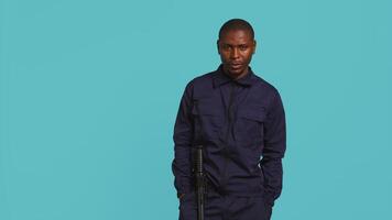 Bored security guard preventing criminal activity, patrolling around premises to deter criminals. Portrait of weary bodyguard walking around, lacking activity, studio background, camera B video