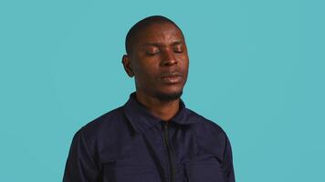 Portrait of security job employee yawning while at work detaining perpetrators, feeling tired. Patrol guard feeling exhausted after long night shift, isolated over studio background, camera B video