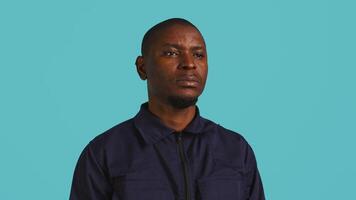 Headshot portrait of security guard at work smiling and overseeing premises. Joyful private law enforcement worker grinning while doing job, close up shot, studio backdrop, camera B video