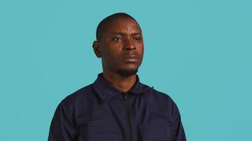 Portrait of security job employee waving hand, being friendly with visitors. Patrol guard follows conduct codes, saluting people, isolated over studio background, camera B video