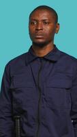 Vertical Security guard tasked with preventing criminal activity and detaining suspects stealing, damaging property, or performing other crimes. Portrait of intimidating bodyguard, studio background, camera A video