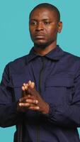 Vertical Portrait of security job employee shooting gun, detaining perpetrators while following legal protocols. Patrol guard follows conduct codes, doing pistol fingers gesturing, studio background, camera A video