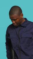Vertical Security guard turning on flashlight, being tasked with preventing criminal activity and detaining suspects performing crimes. Portrait of bodyguard using lantern device, studio background, camera A video