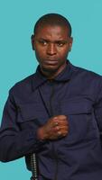 Vertical Security guard standing in fighting stance, prepared to deal with people entering restricted area. Portrait of bodyguard holding defensive pose, ready to throw punches, studio background, camera A video