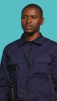 Vertical Security guard in threatening pose, tasked with preventing criminal activity and detaining suspects performing crimes. Portrait of menacing bodyguard crossing arms, studio background, camera A video