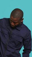 Vertical Portrait of security staff member tasked with evicting trespassers, intimidating them with baton. Patrolling agent maintains secure environment using truncheon weapon, studio background, camera A video