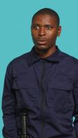Vertical Security guard in uniform feeling amazed while at work, saying wow. Portrait of awestruck bodyguard being astonished during protection job shift, studio background, camera A video