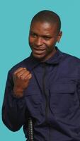Vertical Cheerful security guard celebrating achievements during protection job shift. Portrait of joyous bodyguard feeling satisfied after completing tasked orders, studio background, camera A video