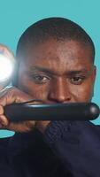 Vertical Headshot portrait of security staff member evicting trespassers with baton after spotting them with flashlight. Close up of patrolling agent using truncheon and lantern to evict intruders, camera A video