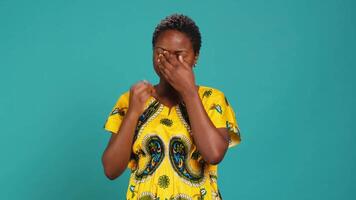 Fatigued girl suffering from burnout and sleep deprivation in studio, yawning and being extremely tired against blue background. Exhausted woman feeling overworked and lazy. Camera A. video