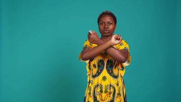 Dissatisfied unhappy person showing a refusal symbol with hands in a stop sign shape, expressing negativity and her rejection for something in studio. Young woman feels displeased. Camera B. video