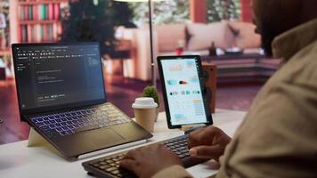 AI software developer creating an algorithm for deep learning and data mining, coding on his laptop at home office. Expert processing binary code on supercomputer neural network. Camera B. video