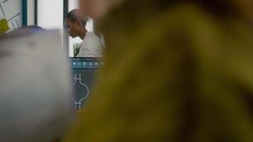 colegas discutindo sobre industrial projeto analisando 3d engrenagens olhando às computador com cafajeste Programas e escrever em pegajoso notas. industrial engenheiro e Gerente trabalhando dentro criativo escritório video