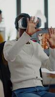 African editor experiencing VR goggles, gesturing, editing film montage working with footage and sound on computer with two displays. Videographer processing movie in creative agency video
