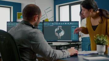 equipe discutindo sobre industrial projeto usando dual monitores configuração para desing 3d engrenagens e metálico braçadeira dentro cafajeste Programas. industrial engenheiro e africano projeto Gerente trabalhando juntos dentro criativo escritório video