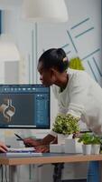 diverso equipe do engenheiros trabalhando em computador às mecânico peça Projeto cafajeste partilha Ideias sobre industrial projeto usando dual monitores configurar. Preto Gerente analisando 3d engrenagens em cafajeste Programas. video