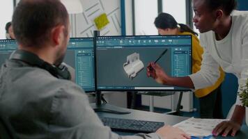 Black employee pointing on monitor explaining to project manager mechanical metalic parts of motor prototype. Industrial engineers using 3D cad program with gears shape working in creative office video