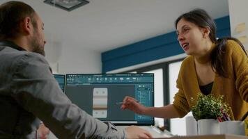 Industrial designer discussing with colleague while working in CAD program, designing 3D prototype of components. Woman engineer using pc with two monitors sharing ideas for construction mechanism video