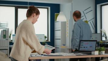 kvinna innehav digital läsplatta zoomning i på försäljning paj Diagram och jämförande data med statistik på bärbar dator skärm och papper på skrivbord. börja anställd arbetssätt med nyckel prestanda indikatorer i kontor. video