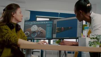 Diverse women game software developers creating game interface sitting in startup creative agency company using pc with two displays. Workers developing online games with modern technology video