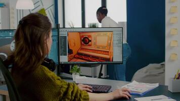 Diverse women game sofware developers testing new game sitting in startup creative agency company using pc with dual monitors setup. Workers developing new online games with modern technology video