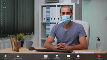 Freelancer talking at camera with prrotection face mask during virtual conference. Pov of entrepreneur working in new normal workplace having online meeting, footage with software overlay concept video