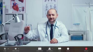Man practitioner doctor offering medical online advice from his office. Physician using virtual discussion to consult patient, telemedicine and healthcare support footage with software overlay concept video