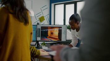 Multiethnic women game designer looking at computer with dual displays working together at project in studio office. Gamer workers developing new online games on pc with modern technology video