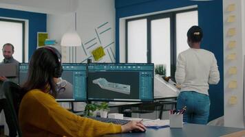 Engineers talking in front on pc and laptop with CAD software innovating efficient motor prototype working in start up industrial company. Architects sharing ideas to develop construction mechanism video