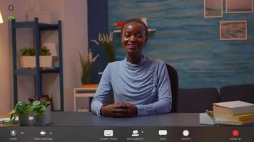 African freelancer working from home talking on camera sitting at desk late at night. Pov of manager having online meeting, webinar with business remotely team, footage with software overlay concept video