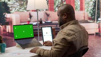 Business owner uses chroma key screen on laptop and calculates financial reports at home desk, accounting specialist calculating budget numbers to expand startup. Entrepreneurship. Camera A. video