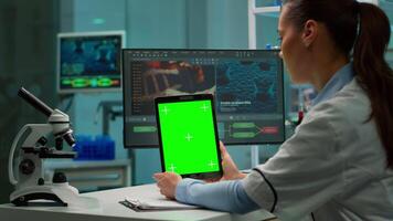 Medical research laboratory portrait of female scientist holding tablet with green chroma key screen. Advanced scientific lab for medicine, biotechnology working for vaccine development. video