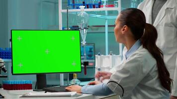 médico hablando con laboratorio técnico y trabajando con verde Bosquejo pantalla escritorio computadora. hombre laboratorio investigador que se discute con médico acerca de vacuna en desarrollo mirando a sangre muestras video