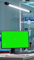 Vertical . Team of scientists working in background of modern laboratory using computer with green screen, mockup display, chroma key monitor, analysing experiment evolution, high tech development lab. video