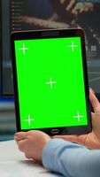 Vertical . Close up of scientist woman holding tablet with green mockup in modern equipped lab. Team of microbiologists doing vaccine research writing on device with chroma key, isolated display. video
