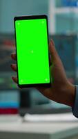 Vertical . Chroma key isolated display on smartphone used by scientist woman in lab cabinet and colleagues in white coat bringing blood sample. Scientist using mobile phone with mockup green screen video