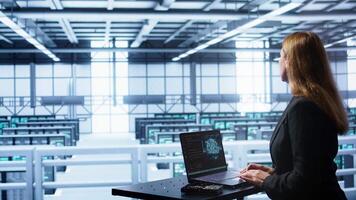 Computer scientist in data center using artificial intelligence computing simulating human brain. IT professional working on notebook with AI machine learning algorithms, camera B video